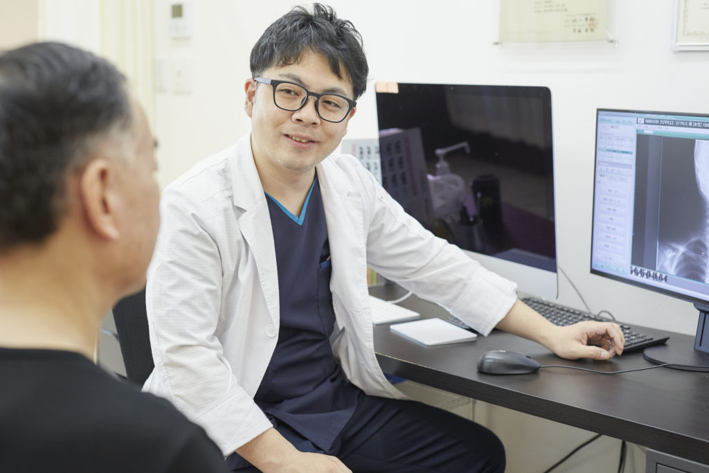 診察室で患者さんに対して説明をしている様子