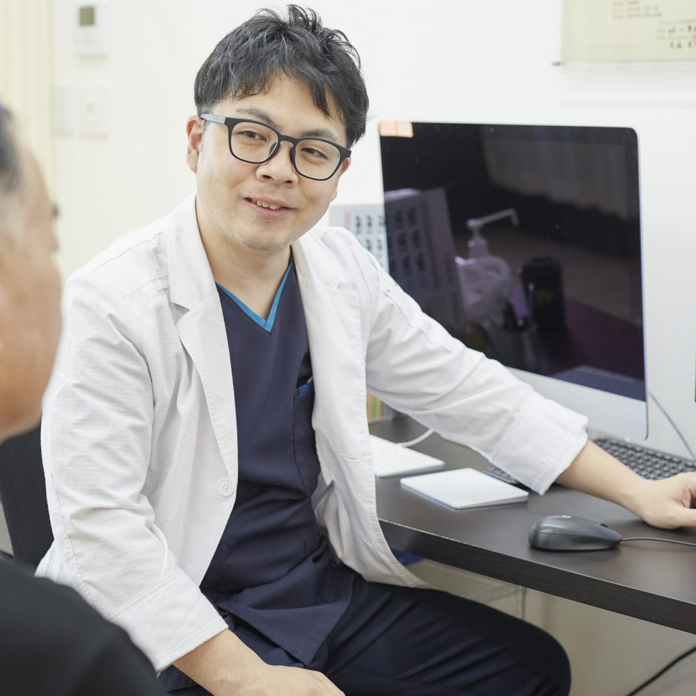 診察室で患者さんに対して説明をしている様子
